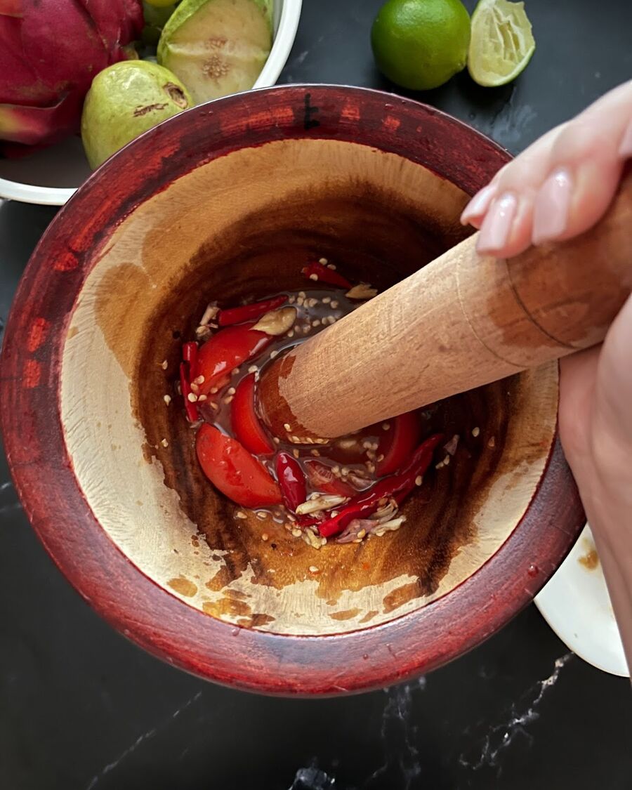 Add the tomato to the mortar and use the pestle to gently bruise the tomato to release its juices.