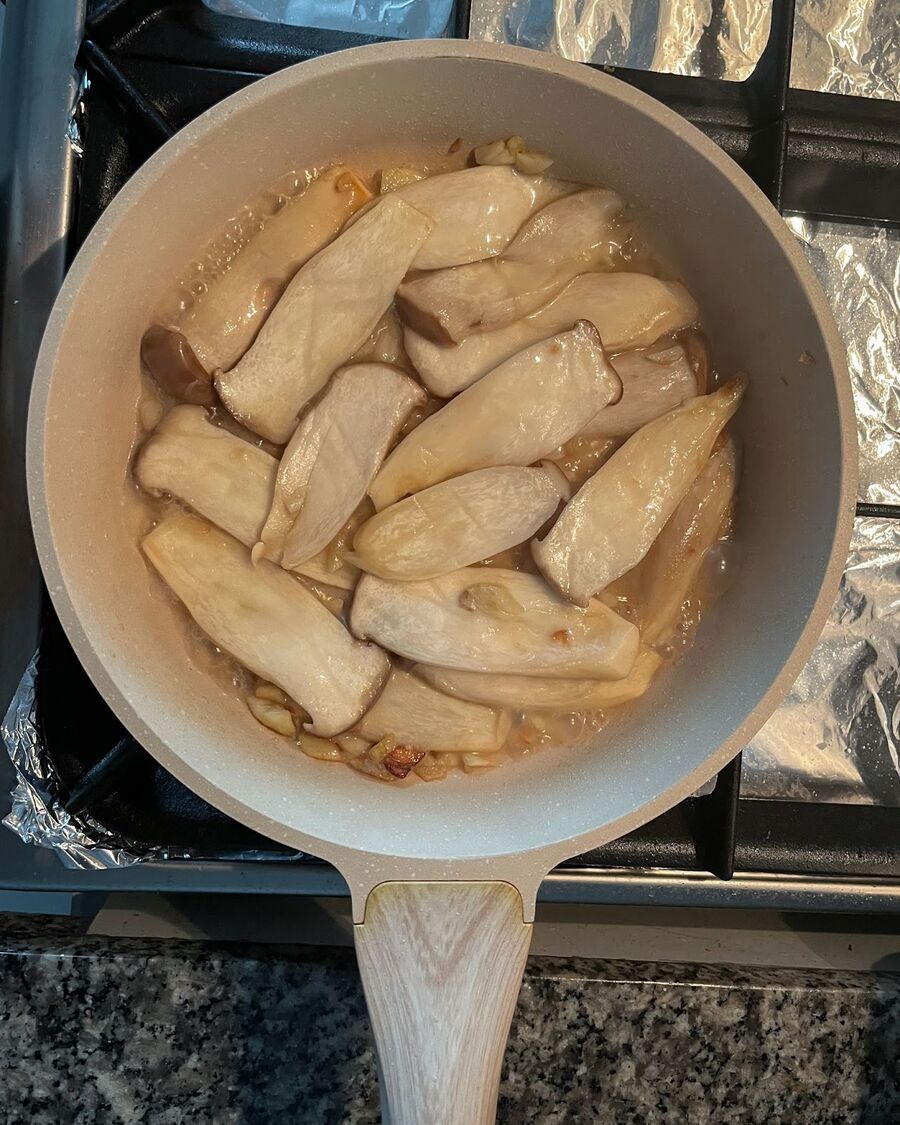 Add the King oyster mushrooms to the pan. Stir them and let them cook for 1-2 minutes. The mushrooms will change color and appear tender.