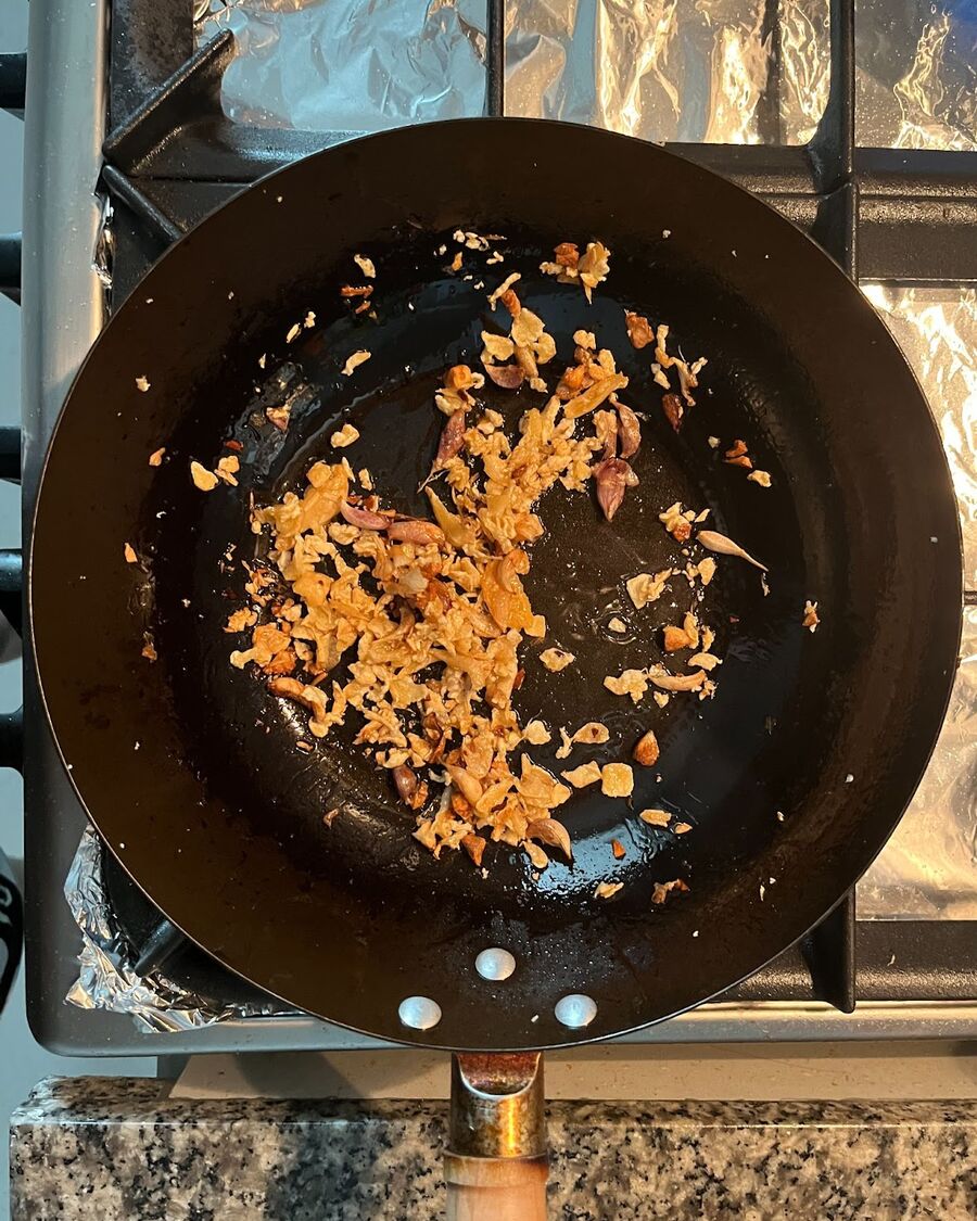 Once the pork spare rib soup is ready, use the same wok pan or pot. Add 2 tablespoons of the fried garlic and the dry cabbage. Stir and combine them well until they become fragrant.