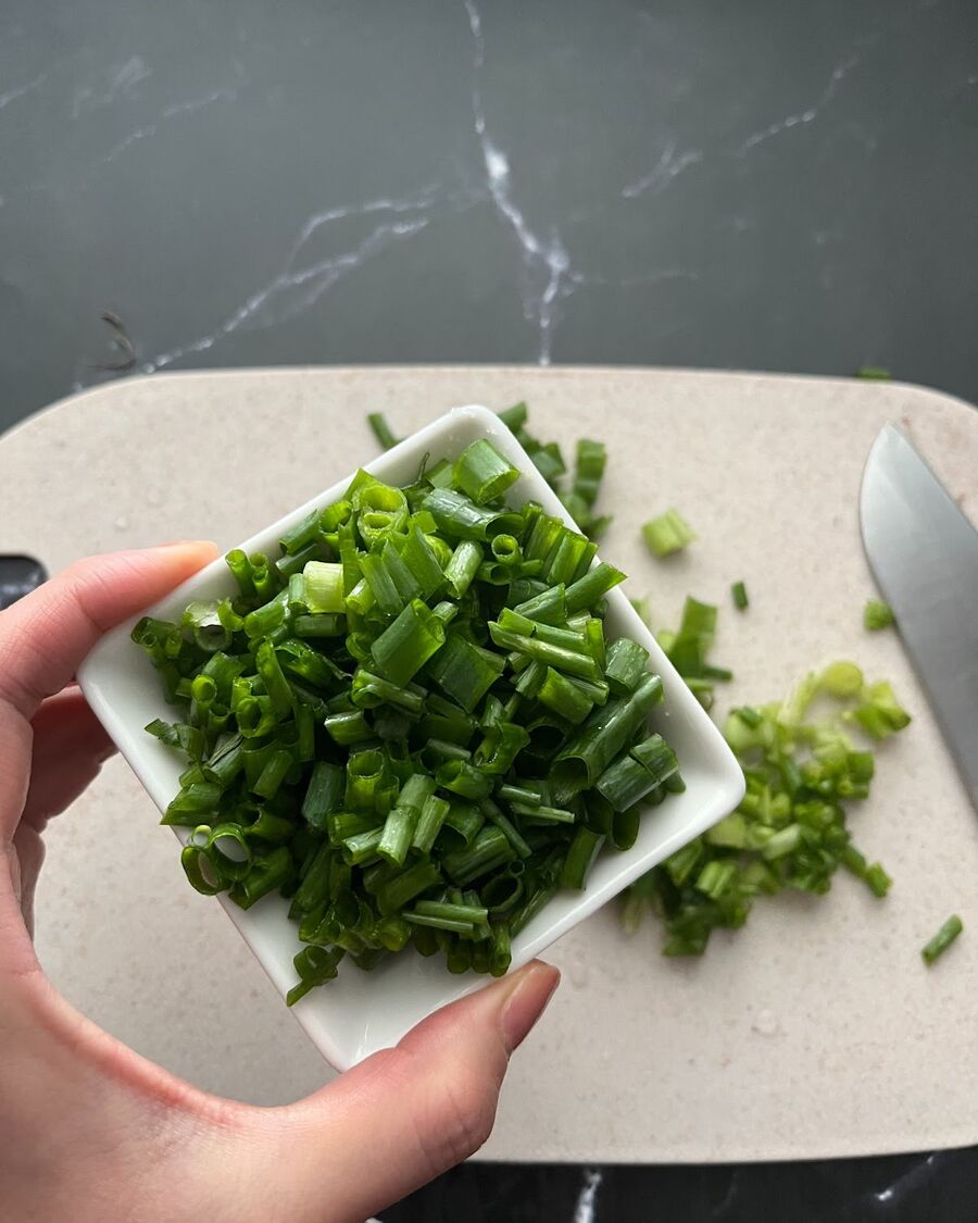 Add ¼ cup of finely sliced green onion to the mixture. Then, pour the combined ingredients into the rice soup pot.