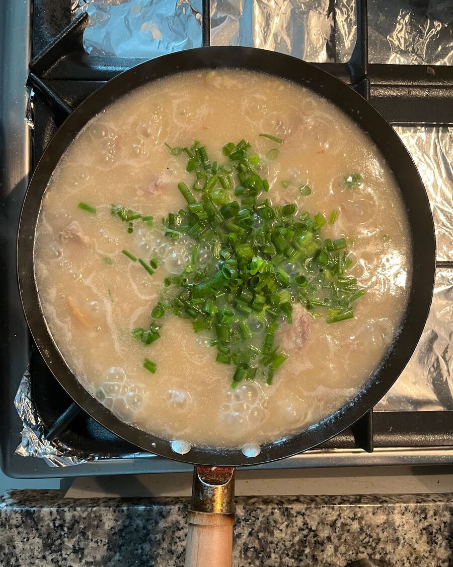 Season the dish with ground pepper and sliced green onion to taste. Stir and combine the ingredients. If the soup appears too dry, you can add about ½ cup of water to achieve your desired consistency.