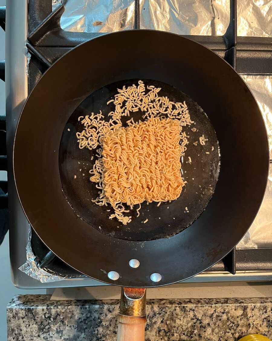 Bring a wok or pot to a boil on medium-high heat. Add the instant noodles to the wok and pour enough water to cover them.