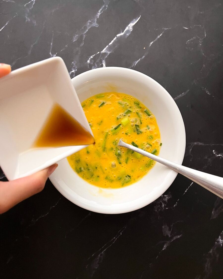 Combine eggs, fish sauce, and spring onion; beat with a fork until frothy.