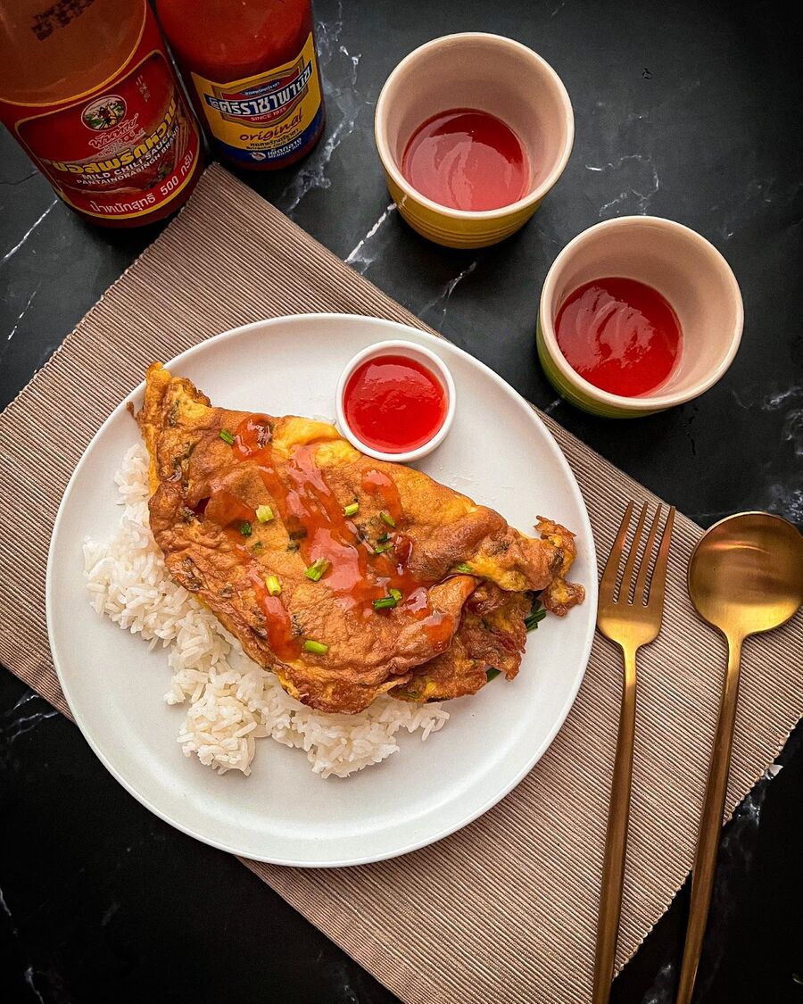 Garnish the Kai Jaew with spring onions and drizzle with Sriracha hot sauce. Enjoy!