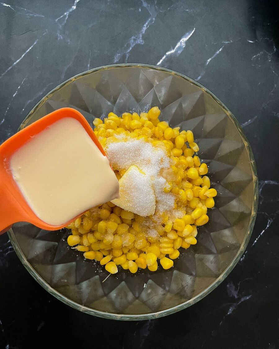 After warming the corn, add butter, sugar, salt, and evaporated milk.