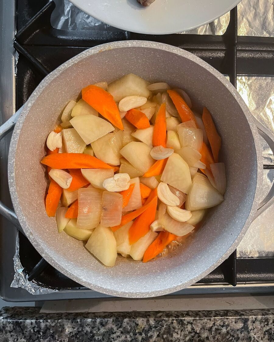 Add carrots, potatoes, and garlic to the pot, stirring to combine them.