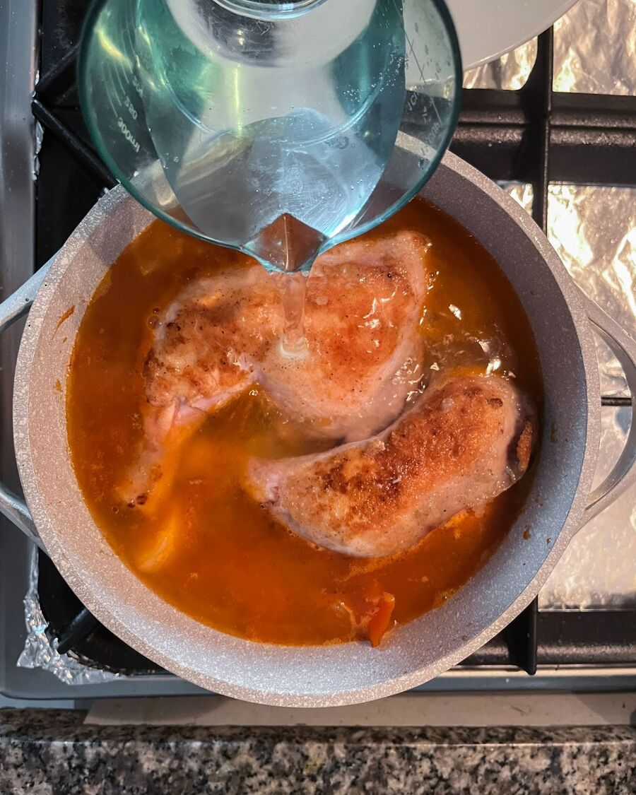 Pour 3 cups of water over the chicken, then cover with the lid and let it simmer for about 20 minutes.
