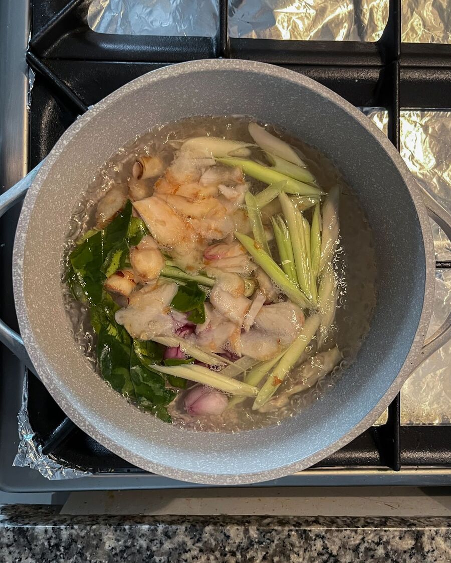 Place a soup pot over medium-high heat. Pour 3 cups of water and add lemongrass, galangal, shallot, coriander root, and kaffir lime leaves to the boiling water. Let the herbs simmer for about 5 minutes until they become fragrant.