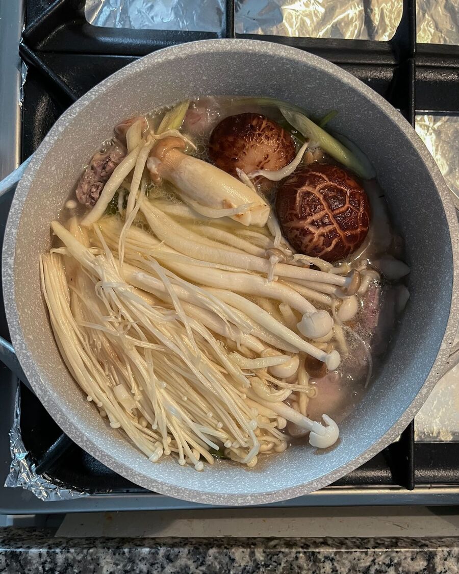 When the chicken is cooked, add all the mixed mushrooms to the pot and let them boil for about 5 minutes.
