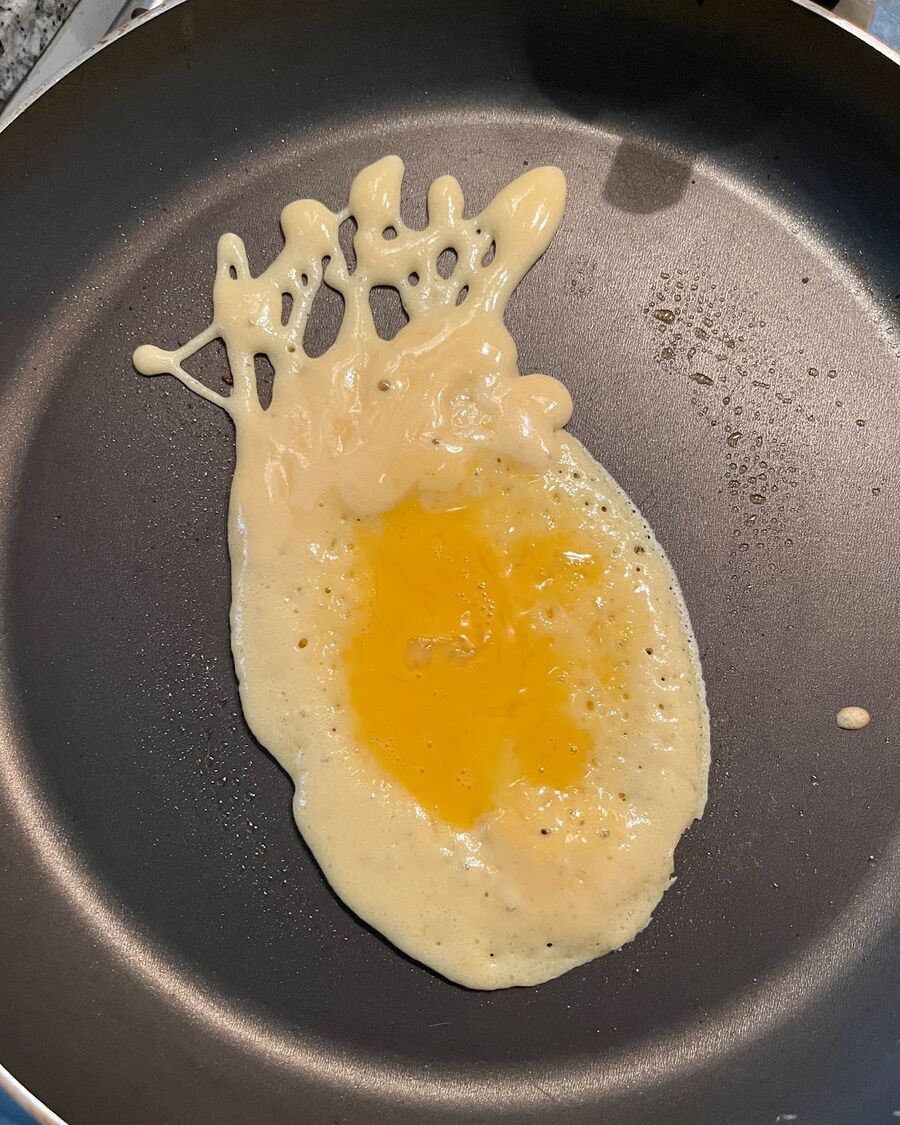 When the pancake is 60% cooked, top it with an egg. Wait for a few seconds until the egg is set.