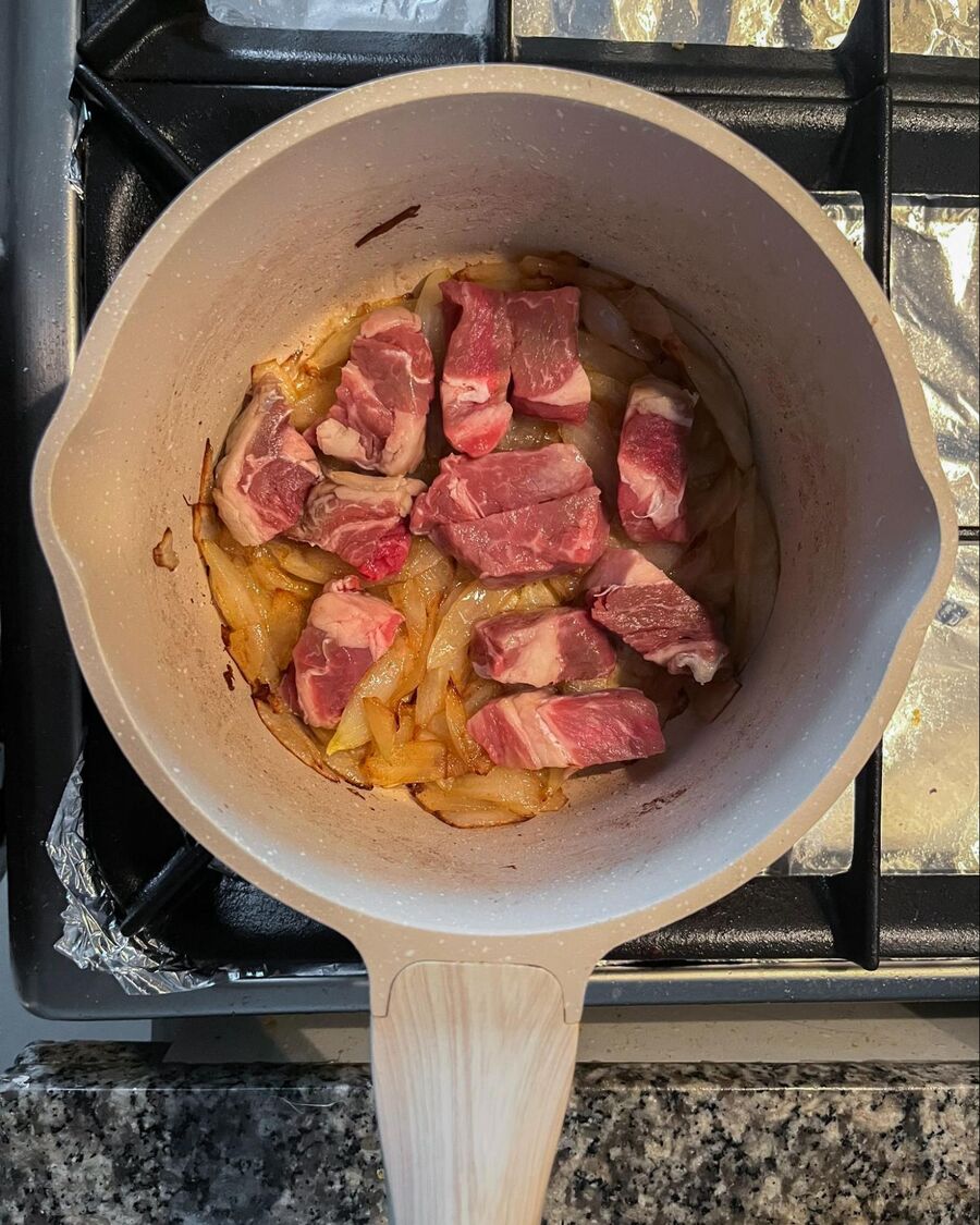 Place a soup pot over medium-high heat. Add the butter and wait for a few seconds until it melts. Add the chopped onion and caramelize for about 5 minutes or until it softens and turns brown. Then, add the beef and combine them well.