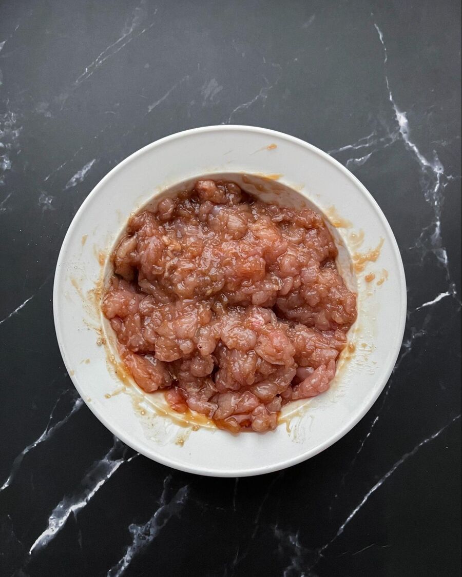 In a mixing bowl, add minced chicken, sesame oil, mushroom sauce, soy sauce, and ground pepper. Combine them well and leave at room temperature for about 5 minutes.