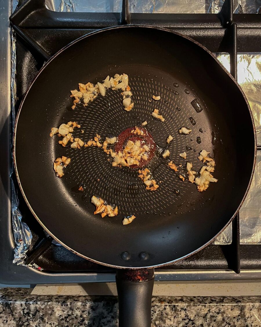 For the filling, heat a pan over medium-high heat. Add some cooking oil and minced garlic, stirring until the garlic is fragrant.