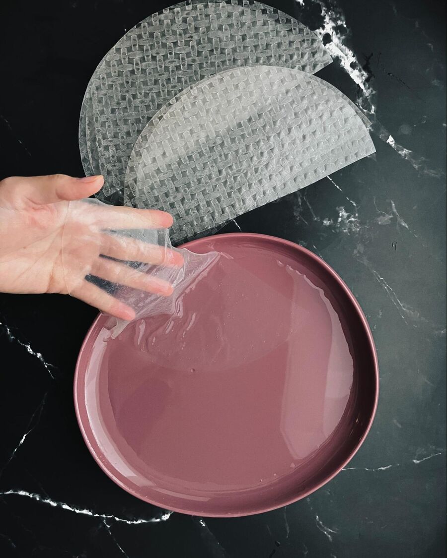 Dip a rice paper in a plate of room temperature water for about 20 seconds. Then place it on a cutting board.