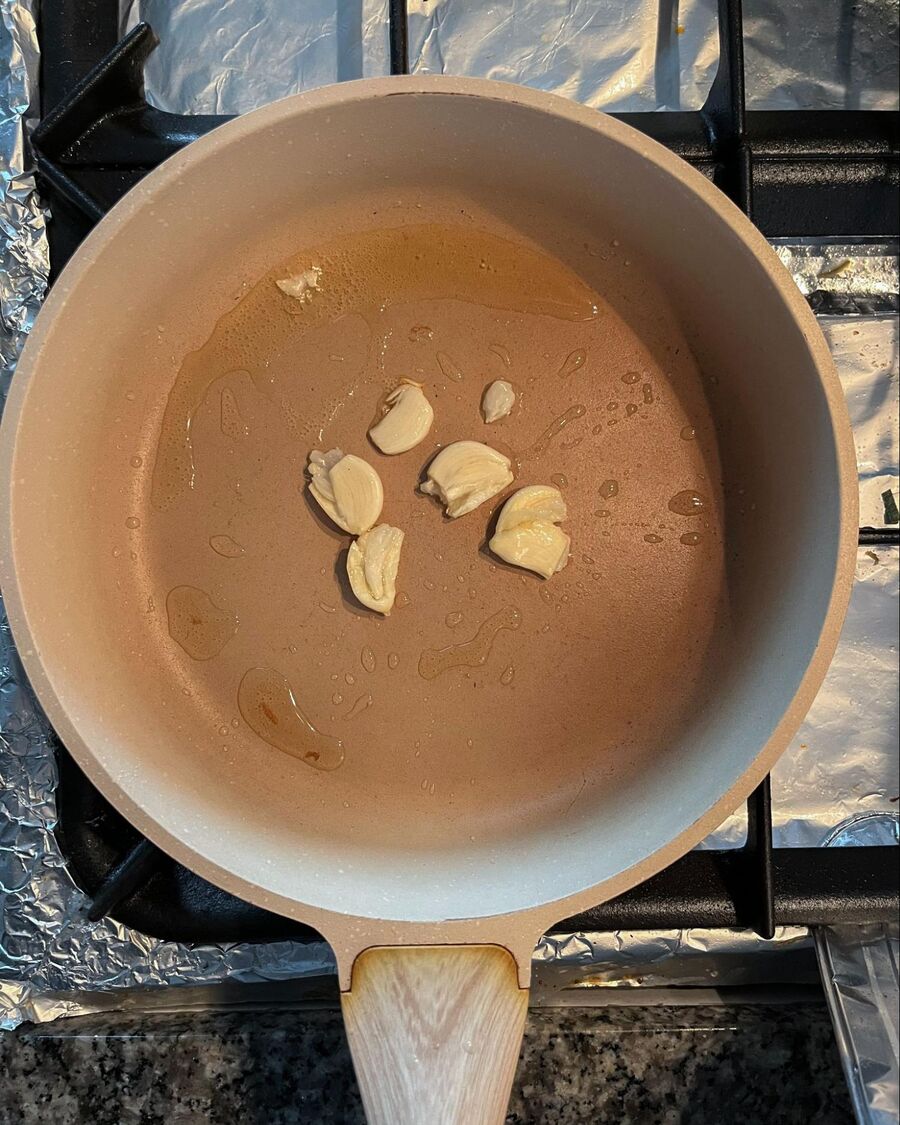 Heat cooking oil in a pan over medium-high heat. Crush the garlic with the side of a knife one or two times to release its fragrance. Then add the crushed garlic to the hot pan.