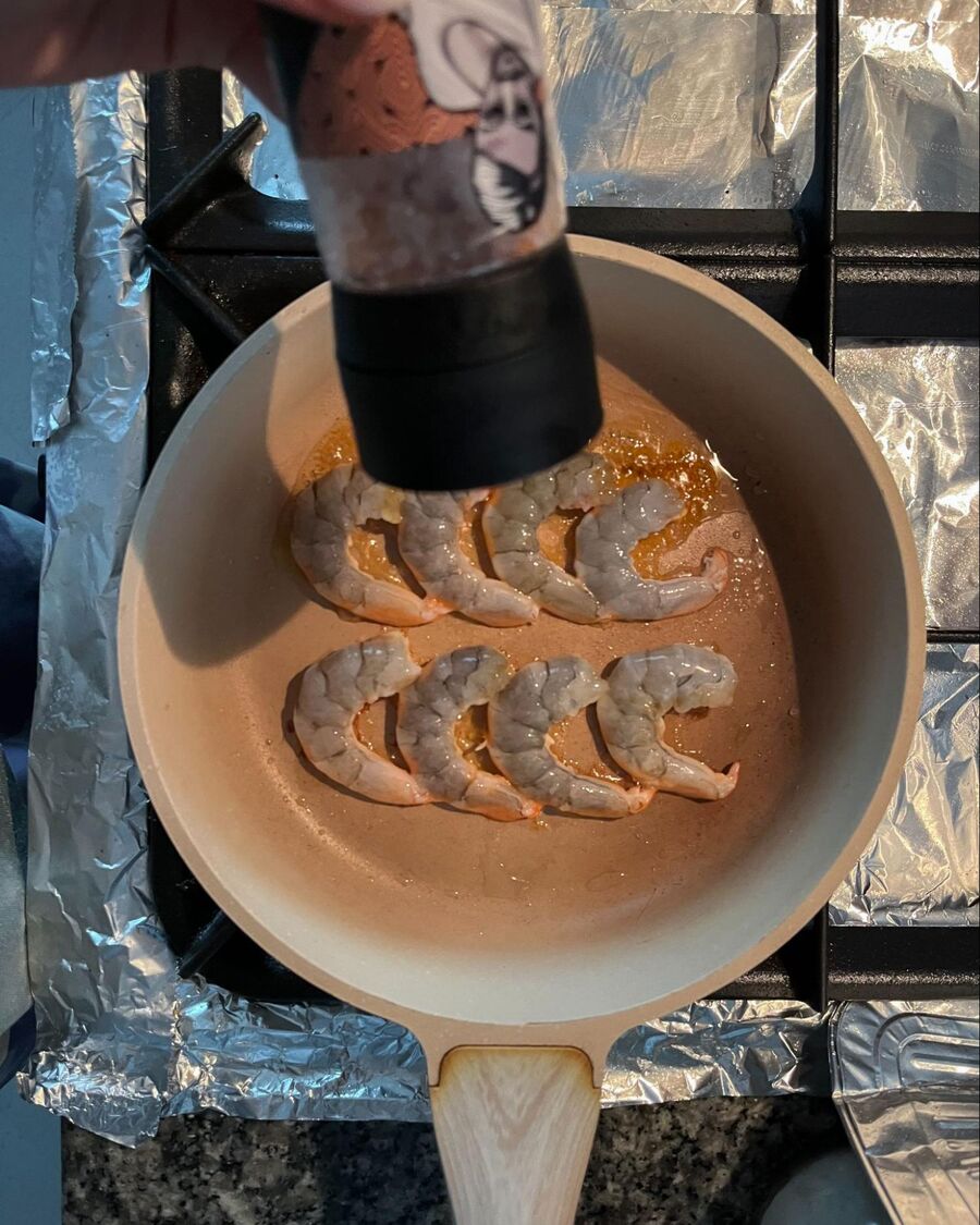 Heat 1 tablespoon of cooking oil in a pan over medium-high heat. Sear the shrimp until they are about 80% cooked, then season with salt and pepper to taste.
