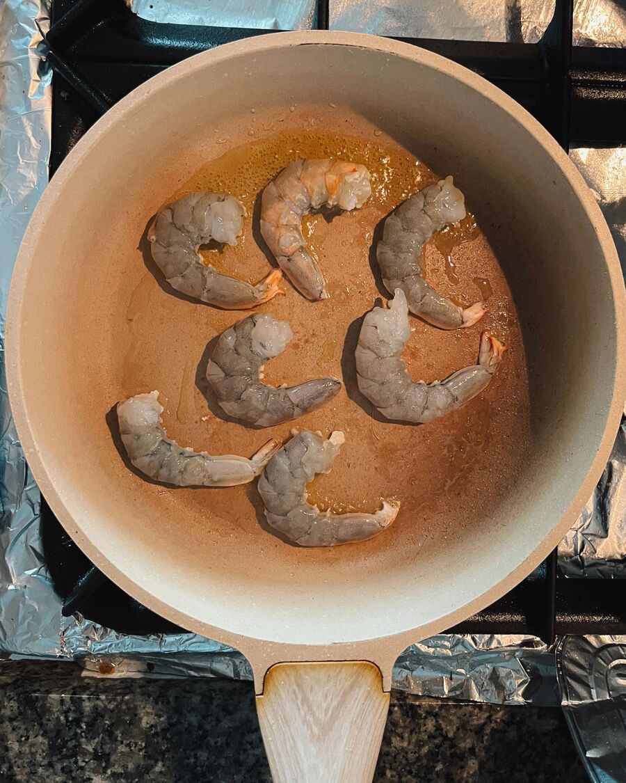 Heat 1 tablespoon of cooking oil in a pan over medium-high heat. Sear the shrimp until they are about 70% cooked.