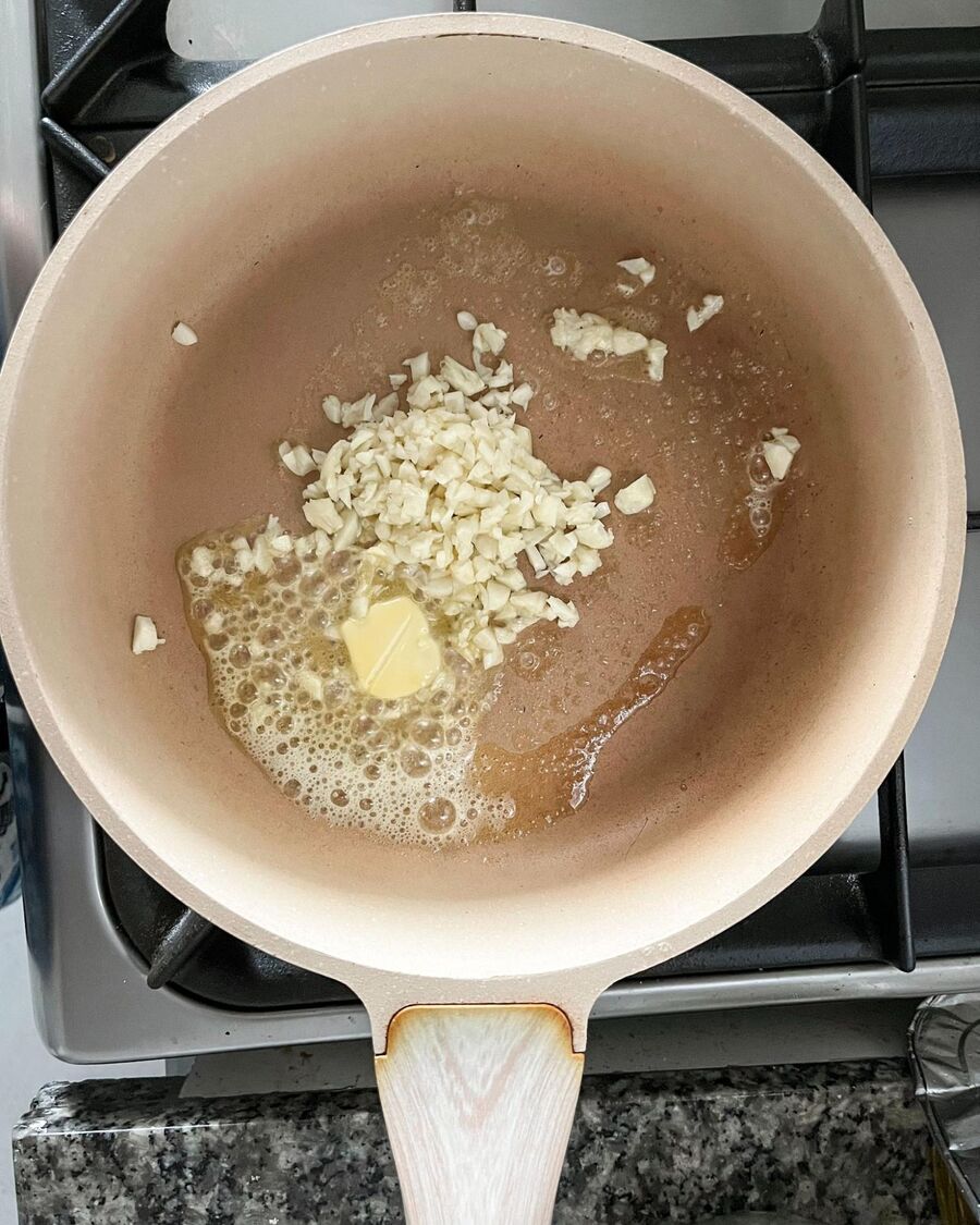 Heat 1 cube of butter in a pan over medium-high heat. Add the minced garlic and stir until it becomes fragrant.