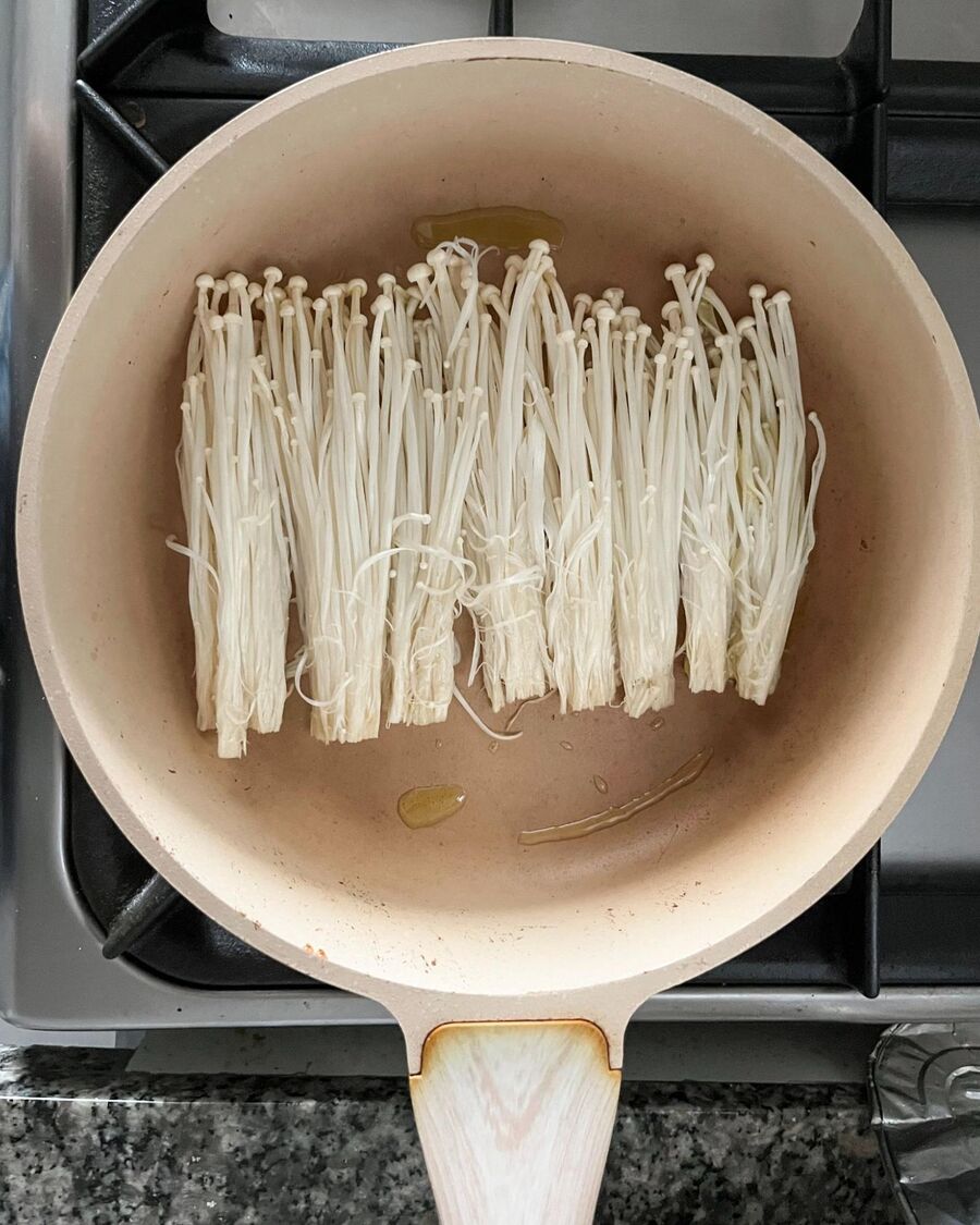 Heat a pan over medium-high heat, add cooking oil, and then place the mushrooms in the pan.