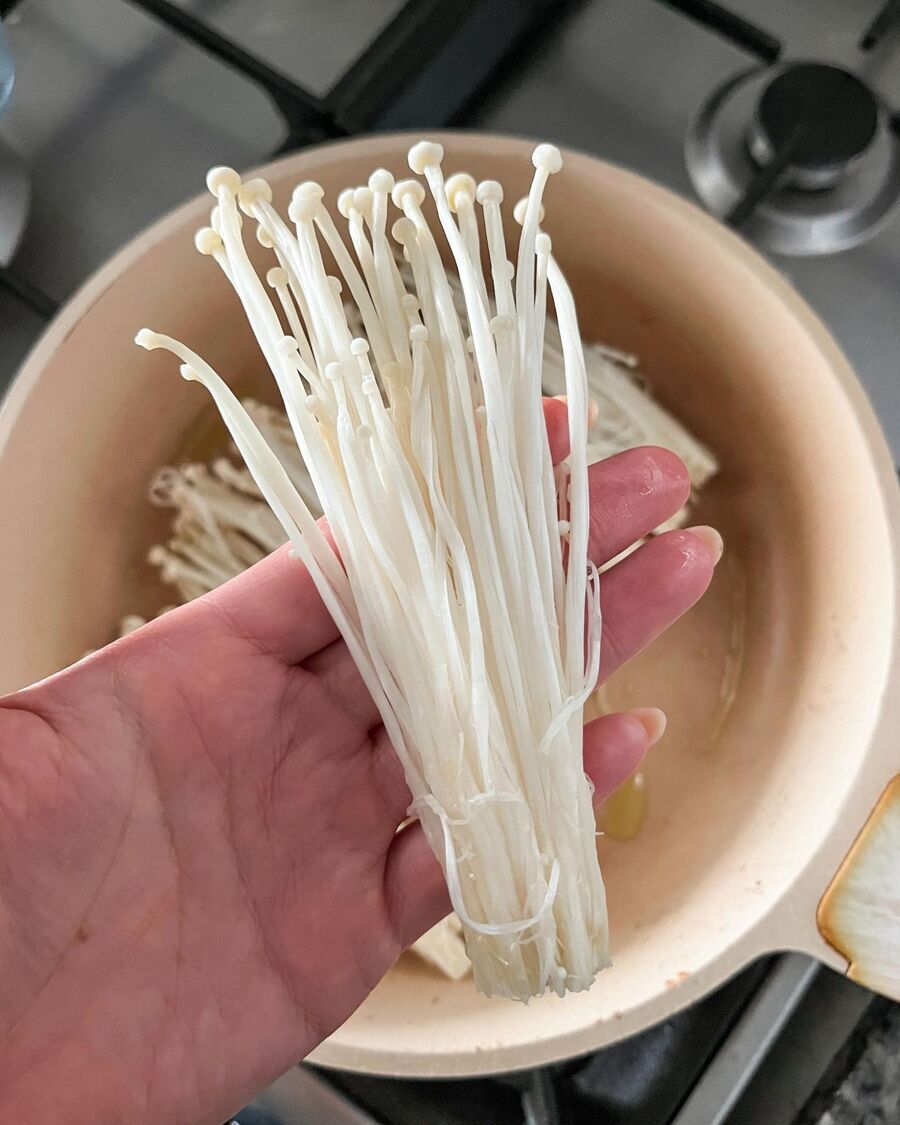 Separate the Enoki mushrooms gently, keeping them attached at the base to form small bundles.