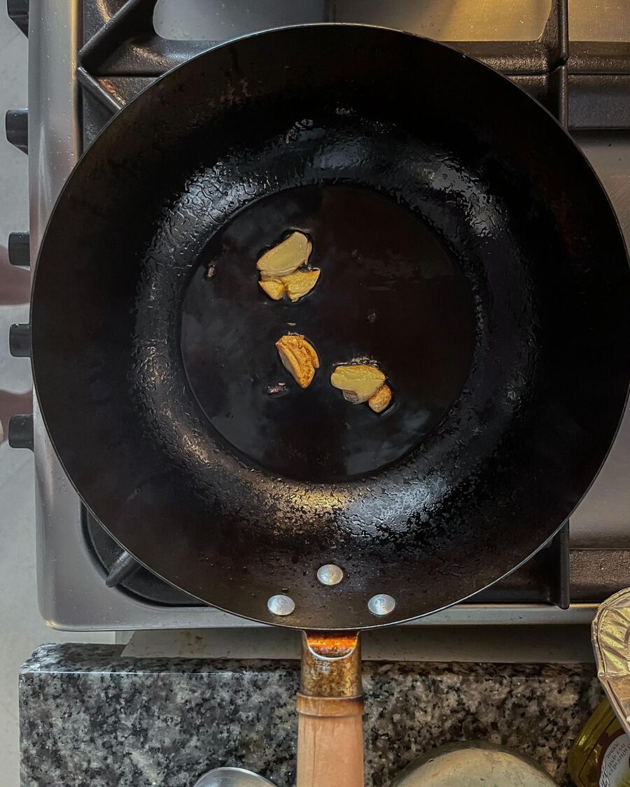 Place a wok or pan over medium-high heat. Once hot, add cooking oil and minced fresh garlic. Stir until the garlic becomes aromatic.