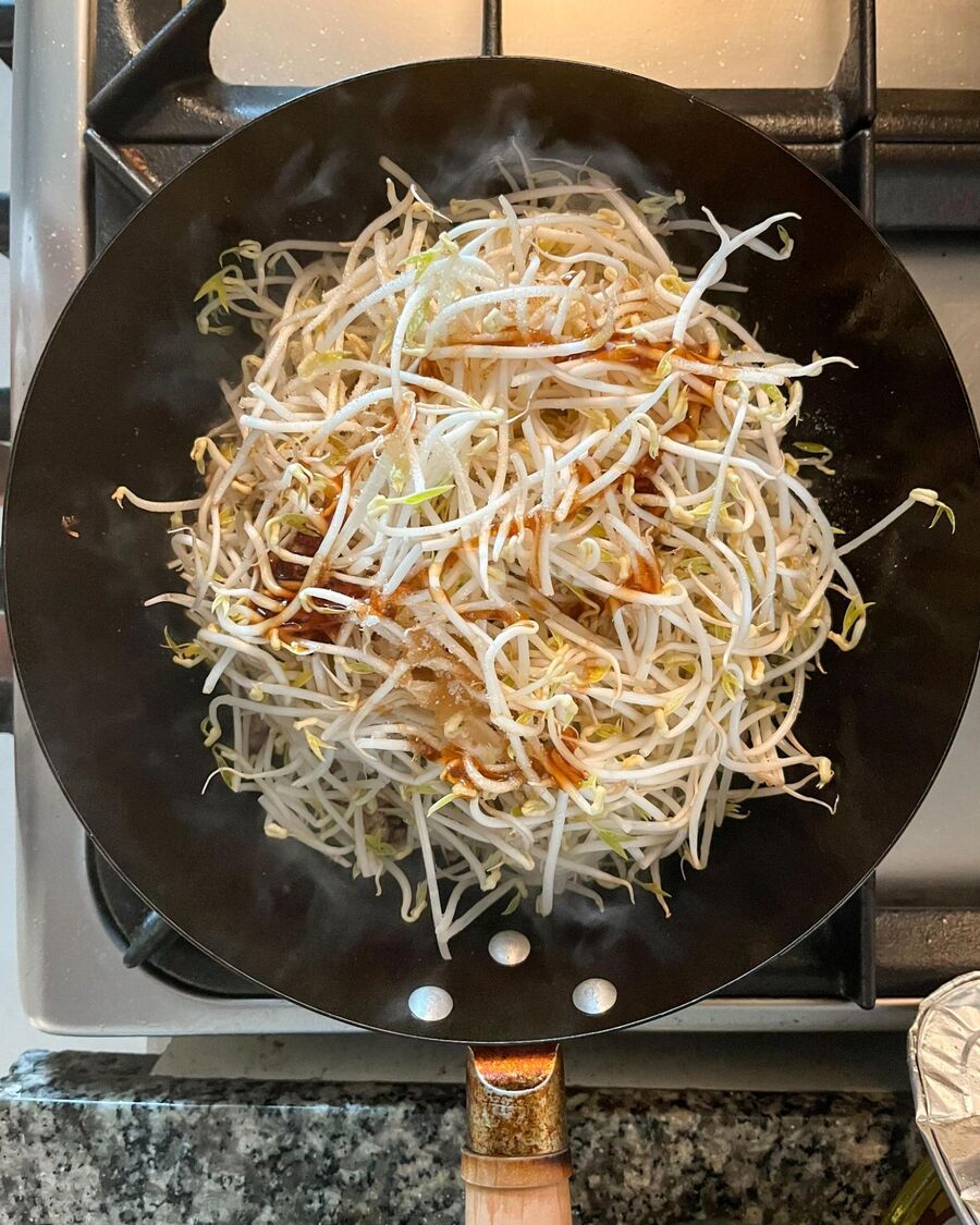 Then, add the bean sprouts, oyster sauce, soy sauce, fish sauce, and sugar on top of the bean sprouts.