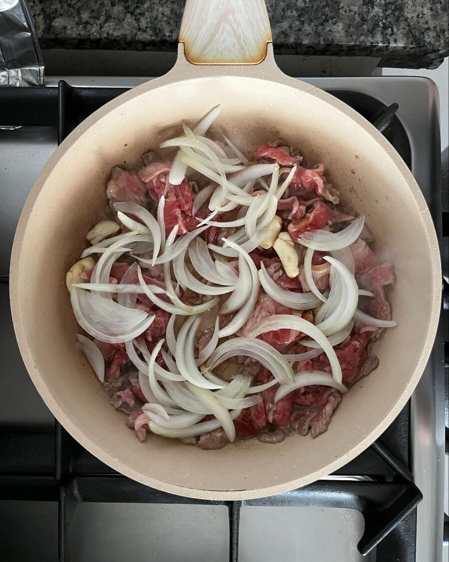 Then, add the sliced onion and stir until well combined and the onion becomes soft.