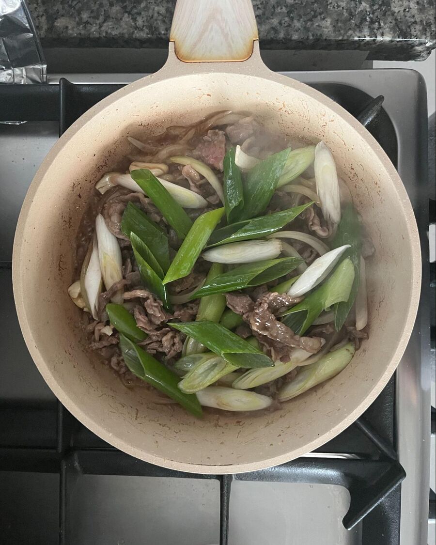 Add the sliced Japanese leeks to the beef.