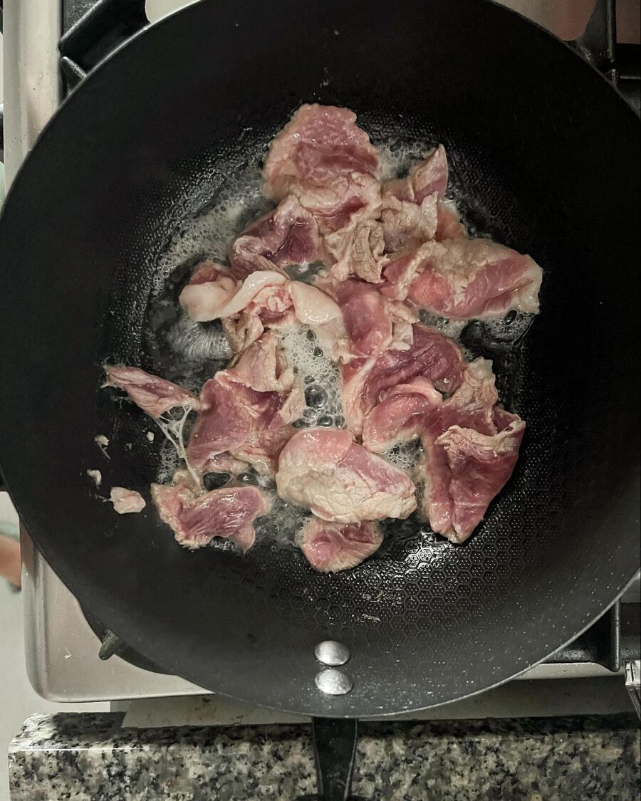 Set a pan over medium-high heat. Add 2 teaspoons of cooking oil and wait until the pan is hot. Toss the pork into the pan and stir. Cook until the meat mostly changes from pink to white.