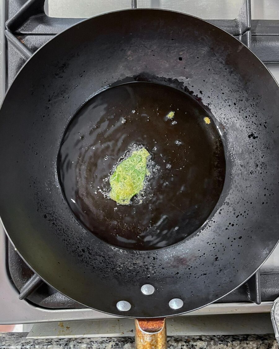 Heat the oil in a pan or wok over high heat until it begins to smoke. Alternatively, drop a single basil leaf into the oil—if it’s hot enough, you’ll see it splatter and pop.