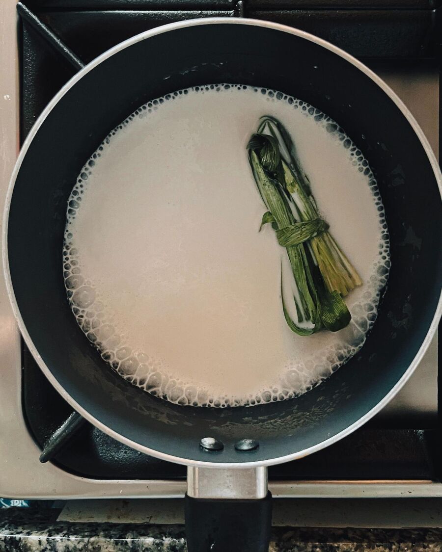 In another pot, combine the coconut milk with a pinch of salt and add the pandan leaves. Stir occasionally over low heat until it starts to bubble.  