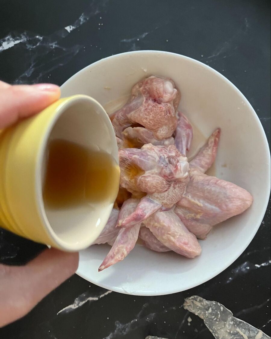 Marinate the chicken wings with fish sauce, salt, sesame oil, and pepper for about 5–10 minutes at room temperature.