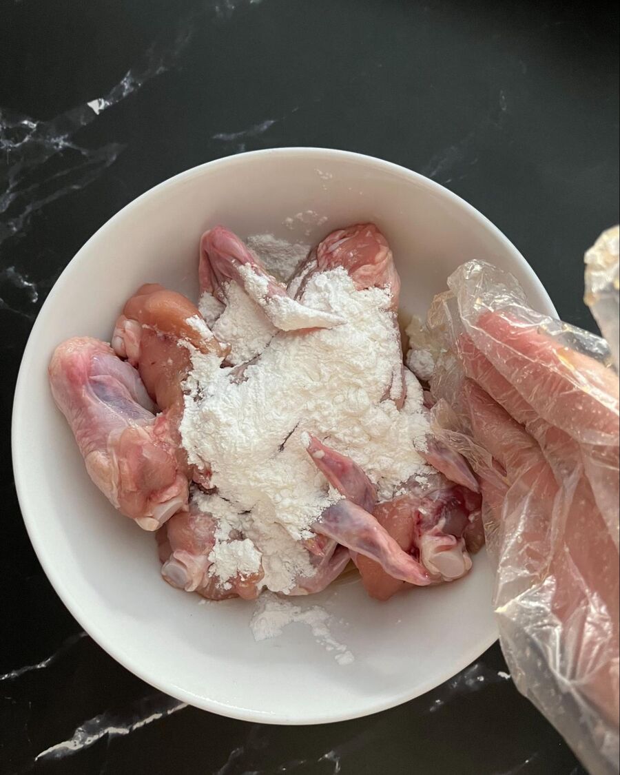 Coat the marinated chicken wings evenly with crispy flour.