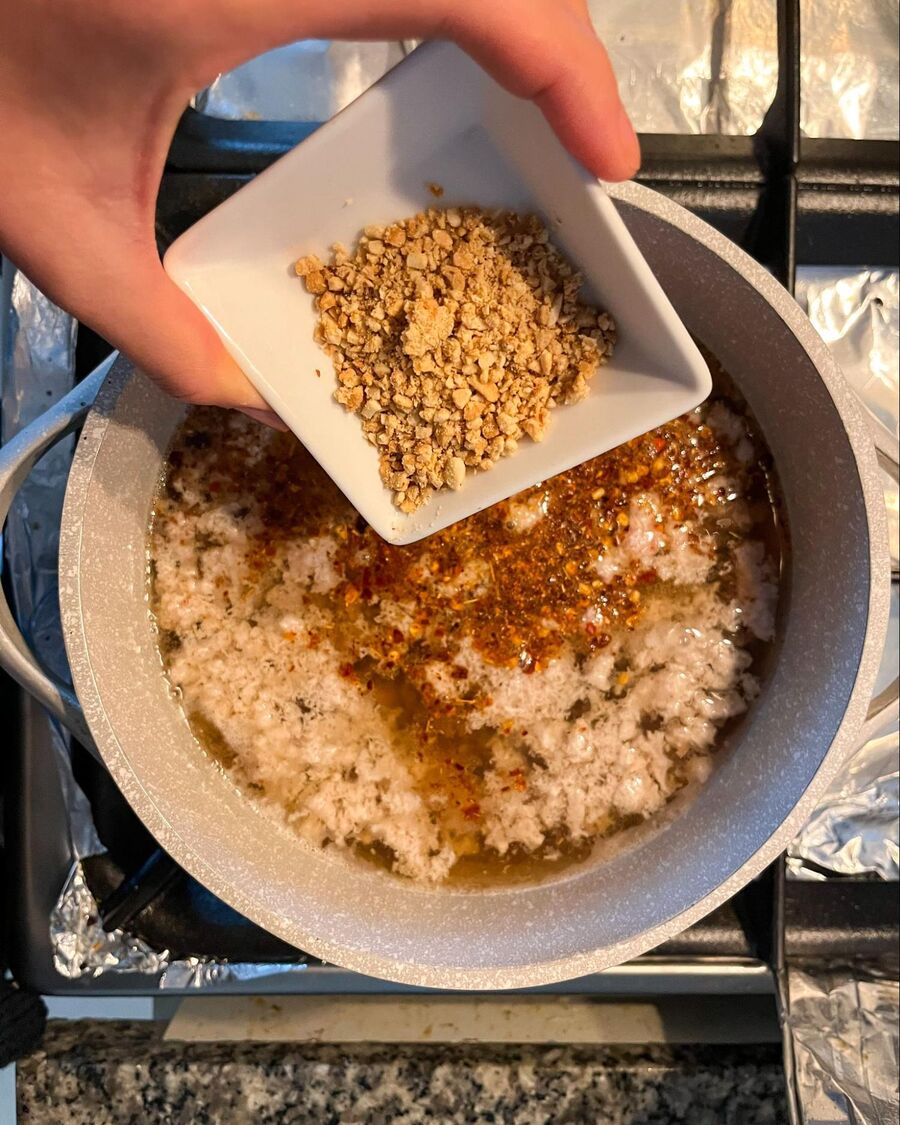 Add the crushed peanuts, fish sauce, and chili powder to the pot, then stir well to combine.