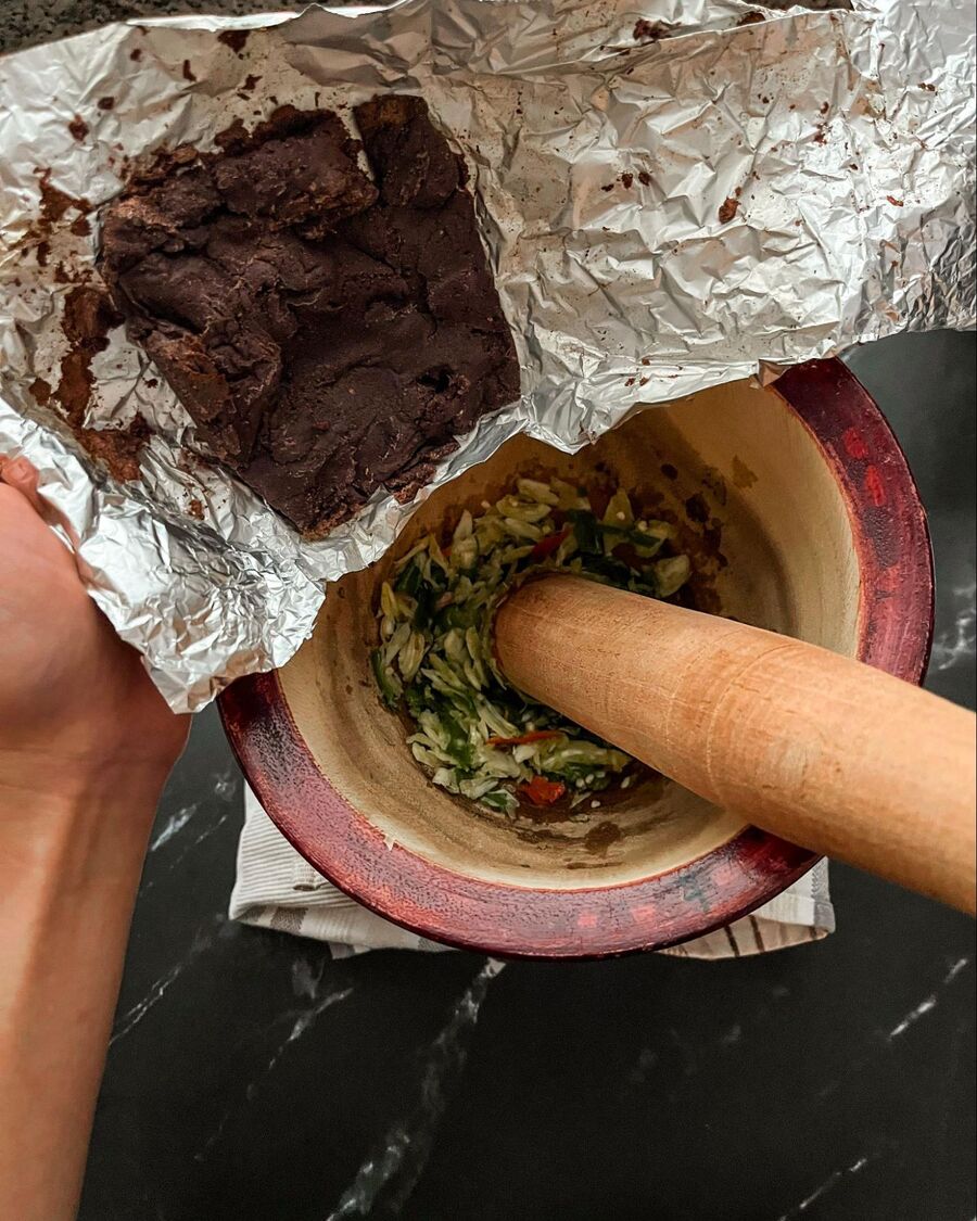 Add the shrimp paste and palm sugar. Pound until the sugar is fully dissolved and everything is well mixed.