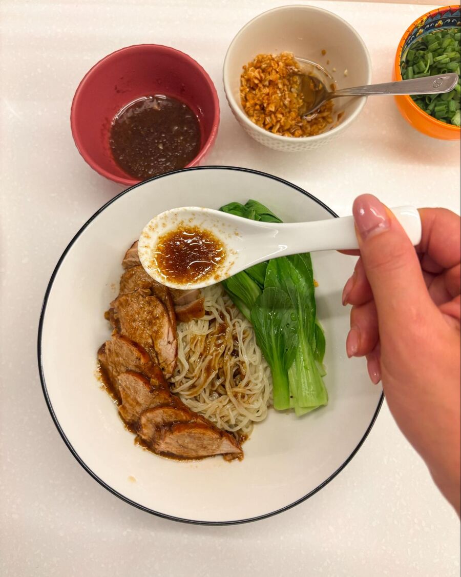 Add the blanched bok choy and sliced pork on top of the cooked egg noodles. Then pour about 1–2 tablespoons of the noodle sauce over everything.