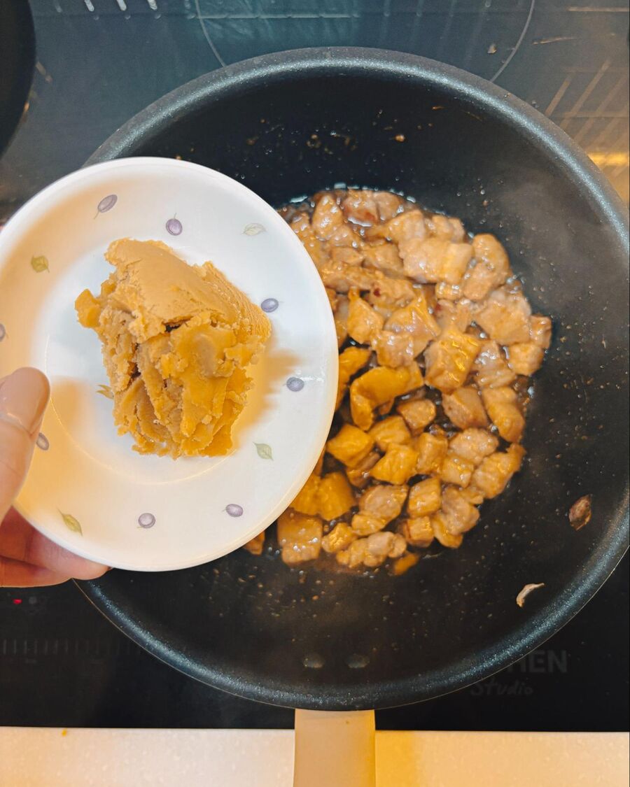 Place a pan over medium heat and add the chopped pork. Cook until the fat starts to render out. Then, add oyster sauce and soy sauce, stirring to combine for a few minutes until the pork is cooked through. Sprinkle palm sugar over the pork and stir continuously until the sugar melts and the pork turns a rich golden brown.
