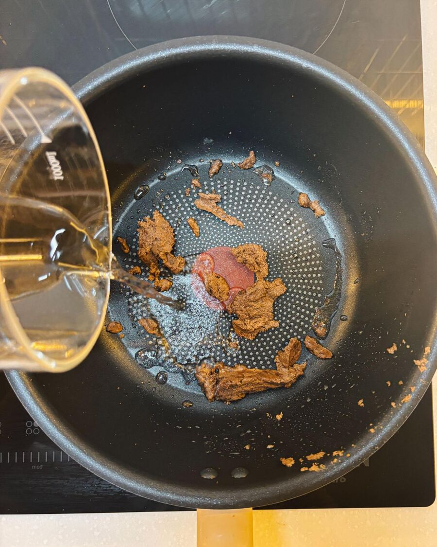 Place a pan over medium-high heat and add 2 tablespoons of cooking oil. Add the shrimp paste and stir-fry for about 2 minutes, until the paste turns brown and fragrant.