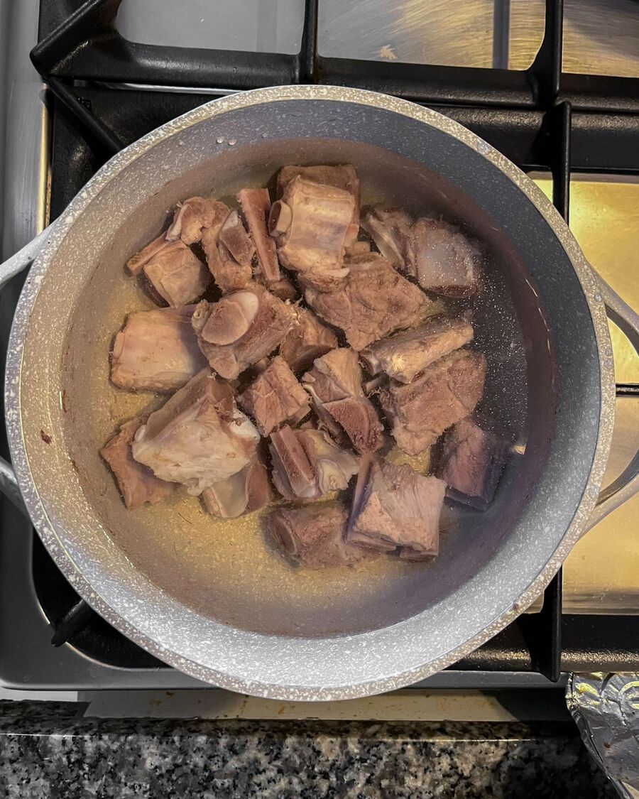Add about 1 liter of water, then simmer the pork bones until tender, approximately 30 minutes.