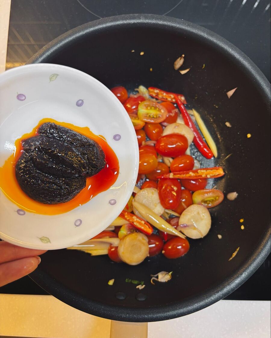 Add the tomatoes and stir for a few minutes until they release their juices. Then add the chili paste and cook briefly to combine the flavors.  