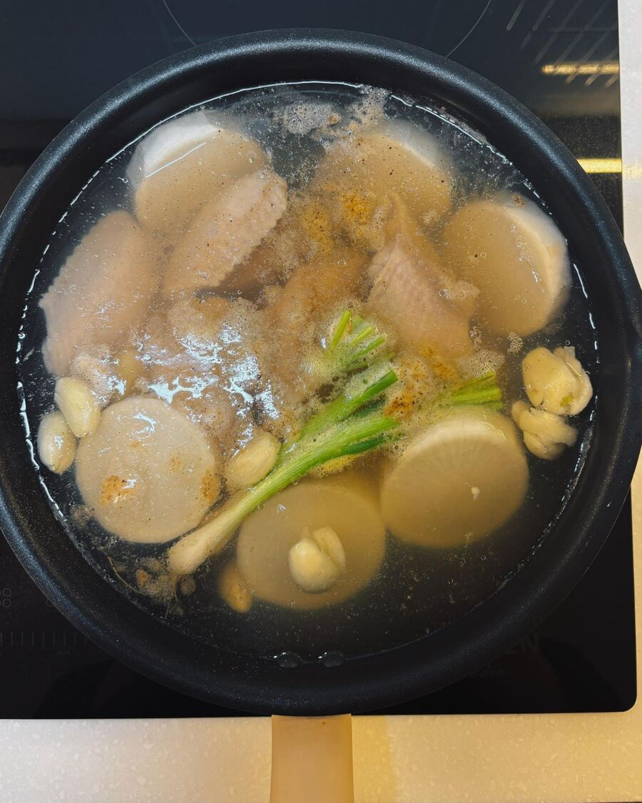 Cut the white radish into small pieces, then add it to the pot and cook for about 10 minutes. After that, add the chicken wings, chicken stock cube, salt, and ground white pepper. Cut the white radish into small pieces, then add it to the pot and cook for about 10 minutes. After that, add the chicken wings, chicken stock cube, salt, and ground white pepper.