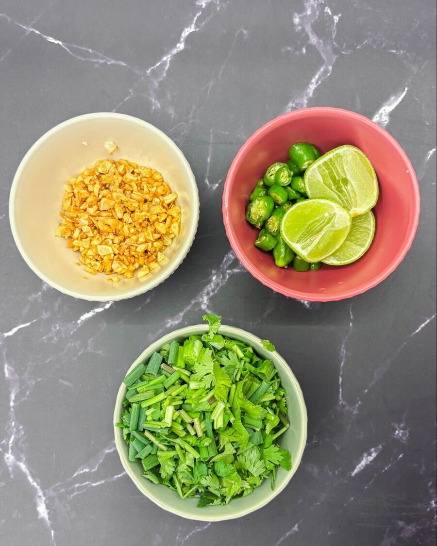 Prepare your condiments: finely chop the coriander and spring onion, slice the fresh chili, and cut the lime into wedges for squeezing. Prepare your condiments: finely chop the coriander and spring onion, slice the fresh chili, and cut the lime into wedges for squeezing.